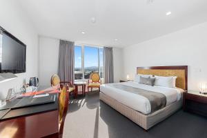 a hotel room with a large bed and a large window at Areca Launceston in Launceston
