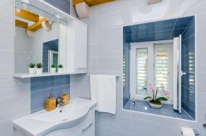 a white bathroom with a sink and a mirror at Apartments Korita in Maranovići +108 photos