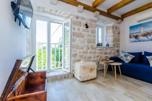 a living room with a blue couch and a window at Apartments Korita in Maranovići
