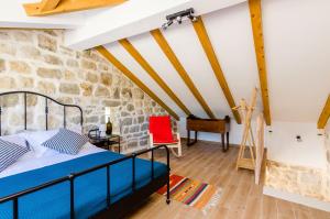 a bedroom with a bed and a red chair at Apartments Korita in Maranovići
