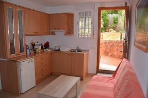 Una cocina con gabinetes de madera y una puerta a un patio. en APARTAMENTO JAZMINERO, en Aguadulce 9 fotos más