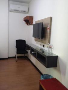 um quarto com uma secretária, uma televisão e uma cadeira em Maxi Inn em Bintulu