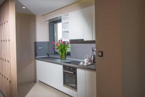 a kitchen with white cabinets and a vase of flowers at Best Western Premier Plovdiv Hills in Plovdiv