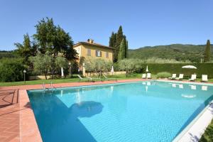 een groot blauw zwembad voor een huis bij Podere San Giusto in Figline Valdarno