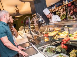 a group of people standing in a kitchen preparing food at Midlands Park Hotel in Portlaoise