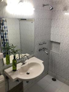 Baño blanco con lavabo y espejo en Sailors Home - C6, Vasant Kunj en Nueva Delhi