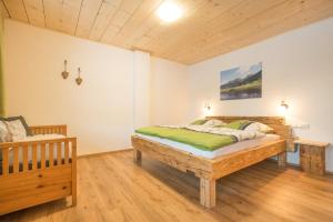 a bedroom with a wooden bed and a chair at Landhaus Panorama in Bad Hindelang
