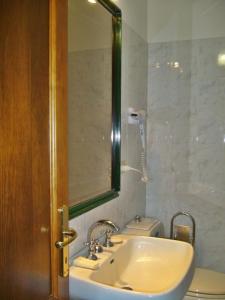 La salle de bains est pourvue d'un lavabo, de toilettes et d'un miroir. dans l'établissement Casa vacanza a due passi dal mare, à Alghero