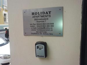 Znak na ścianie z licznikiem płac w obiekcie Holiday Apartments w Karlowych Warach +37 zdjęć
