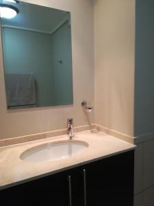 a bathroom with a sink and a mirror at A310 Lagoon Beach Apartment & Spa in Cape Town