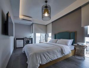 a bedroom with a large bed and a kitchen at RGB Stay Life in Tainan