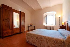 1 dormitorio con 1 cama, armario y ventana en Agriturismo La Moraia, en Poggibonsi