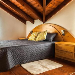 a bed in a room with a wooden headboard at eSense - Formosinha in Madalena