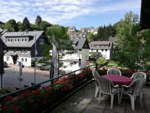 a balcony with a table and chairs and a view of a city at Hotel Garni "Zur Alten Post" in Willingen