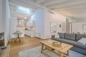 ein Wohnzimmer mit einem Sofa und einem Tisch in der Unterkunft Apartaments Catedral – Baltack Homes in Girona