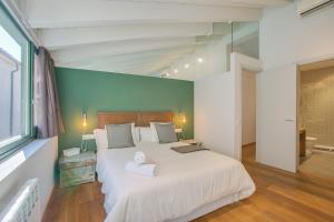 ジローナにあるApartaments Catedral – Baltack Homesの緑の壁のベッドルーム1室(大型ベッド1台付)