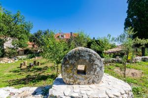 una gran escultura de piedra sentada en la parte superior de un campo en Apartments Korita en Maranovići