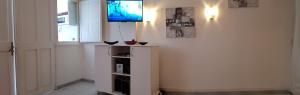 a living room with a television on a wall at ANSE DES ROCHERS St François CORAIL 306 in Saint-François