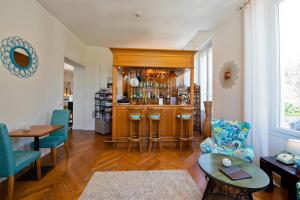 a living room with a bar with blue chairs at Hôtel La Villa Cap d’Antibes in Juan-les-Pins