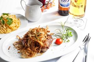 a white plate of food with pasta and spaghetti at Hotel-Gasthof Rössle in Ulm