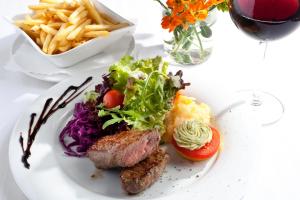 un plato de comida con carne y verduras y patatas fritas en Hotel-Gasthof Rössle en Ulm