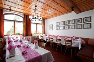 a dining room with tables and chairs with pink napkins at Hotel-Gasthof Rössle in Ulm