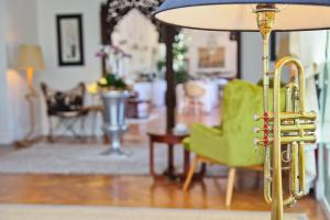 a living room with a yellow chair and a lamp at Hôtel La Villa Cap d’Antibes in Juan-les-Pins