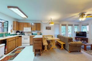 a kitchen and living room with a table and a couch at Towering Pines Cabin & Game Room in Leavenworth