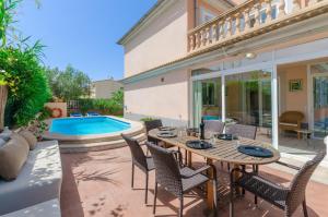 a patio with a table and chairs and a swimming pool at Es Repos in Playa de Muro