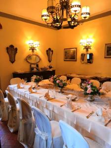 a long table with white tables and chairs in a room at Villa Aurora di Ferracciano in Borgo San Lorenzo