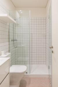 a white bathroom with a shower and a toilet at APOSENTUS - The Wine Studio in Porto +23 photos