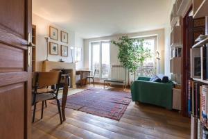 un soggiorno con divano verde e tavolo di séjour Haut Marais a Parigi