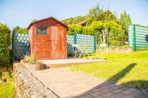 een houten schuur in een tuin met een hek bij Casa Susanna in Wald-Michelbach