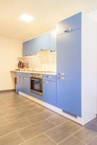 eine große Küche mit blauen Schränken und Fliesenboden in der Unterkunft Casa Susanna in Wald-Michelbach