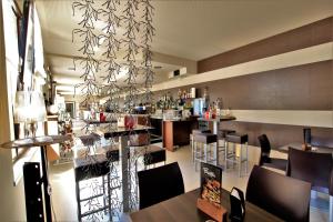 un restaurante con un bar con mesas y sillas en Hotel Oasi Verde, en Bienno