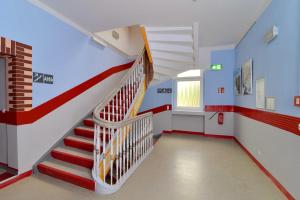 una escalera en una habitación con paredes rojas y azules en Hostel in Guben, en Guben