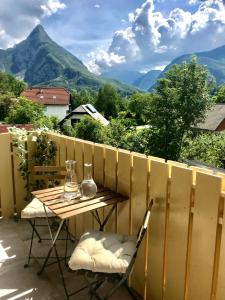 a table and chairs on a balcony with mountains at Summer House Bovec in Bovec