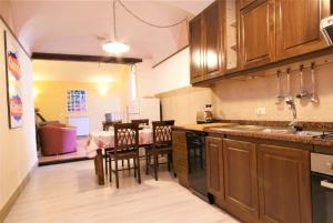 a kitchen with wooden cabinets and a table with chairs at da Patrick in Costarainera