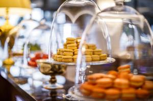 a table with two plates of pastries and a glass dome at Hotel Bellevue - Liburnia in Opatija