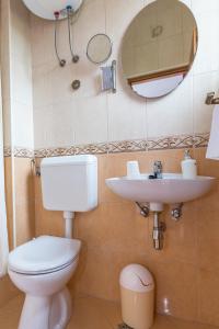 bagno con servizi igienici, lavandino e specchio di Apartments Jure a Makarska