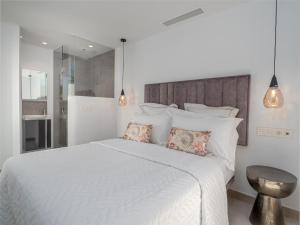 Un dormitorio con una cama blanca con dos almohadas. en Marbella Old Town : Luxury Townhouse, en Marbella