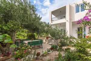 un jardín con un banco verde frente a un edificio en Apartments Jure, en Makarska