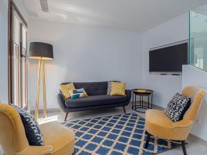 Una sala de estar con un sofá y sillas y un televisor. en Marbella Old Town : Luxury Townhouse, en Marbella
