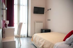 a bedroom with a bed and a tv on the wall at Casa del Marchese B&B in Riposto