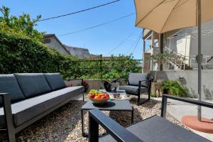 a patio with a couch and a bowl of fruit on a table at Apartments Morpheus in Makarska