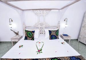 a bedroom with a white bed with a heart on it at Watamu Sunflower House in Watamu