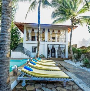 a row of surfboards are lined up in front of a house at Watamu Sunflower House in Watamu