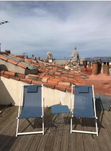 deux chaises bleues assises au-dessus d'un toit dans l'établissement Maison Du Vieux Panier Vieux Port, à Marseille