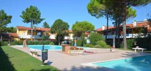 a swimming pool in a yard next to a house at Villaggio Nautilus in Bibione