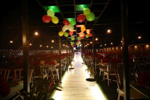 艾哈邁達巴德的住宿－Hotel Avaante Ahmedabad Formerly known as The Orchid Hotel，一间设有桌椅和悬挂在天花板上的气球的房间